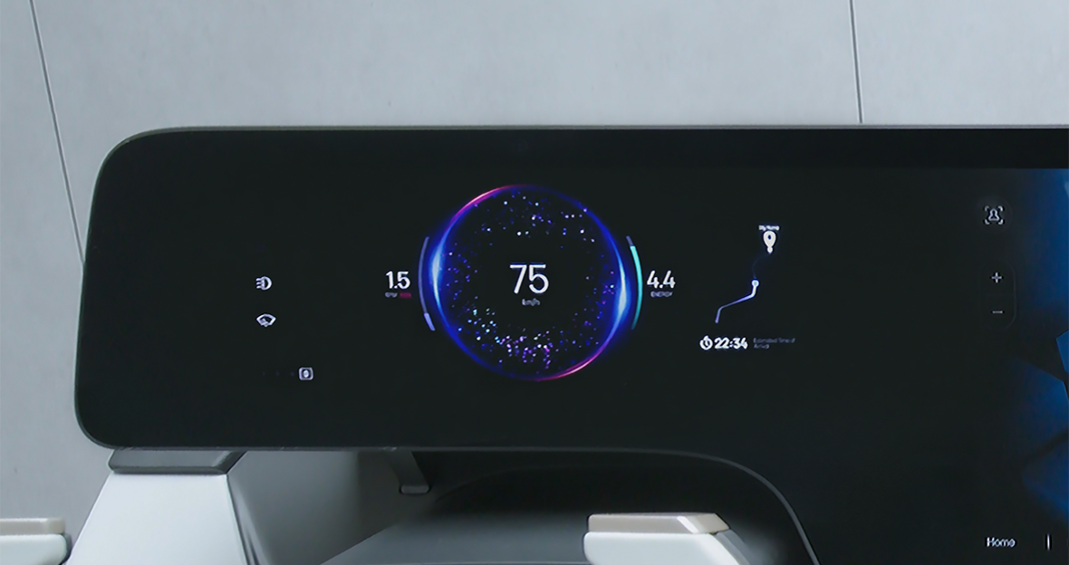 A camera lens is mounted under a modern car dashboard that displays digital speedometer, fuel, and navigation information together, withour a separate notch or hole.